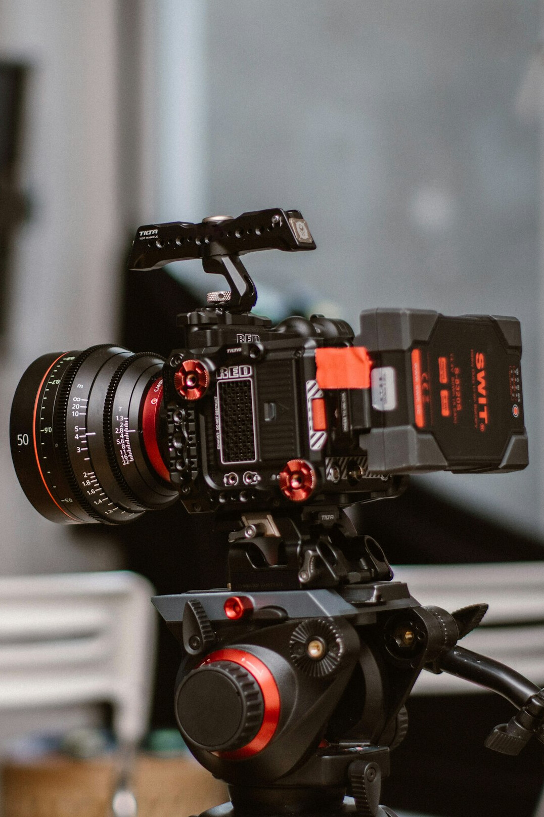 Broadcast camera on a pedestal facing a television news desk in a studio